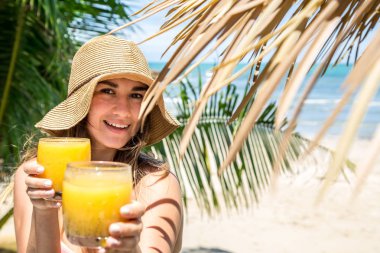 Yaz şapkalı, palm arka plan üzerinde taze bir içkiyle güzel kız sahilde tatil kavramı bırakır