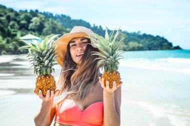ananas bir egzotik plaj, mutlu bir ruh hali ve güzel bir gülümseme ile güzel kız