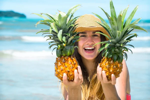 Hermosa chica con piña en una playa exótica, un estado de ánimo feliz y una hermosa sonrisa — Foto de Stock