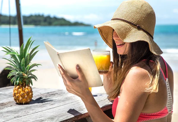 Una chica lee un libro junto al mar — Foto de Stock