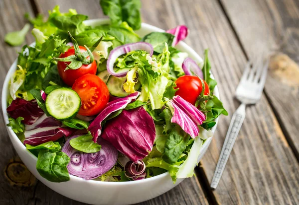 Frischer Salat auf einem hölzernen Hintergrund — Stockfoto