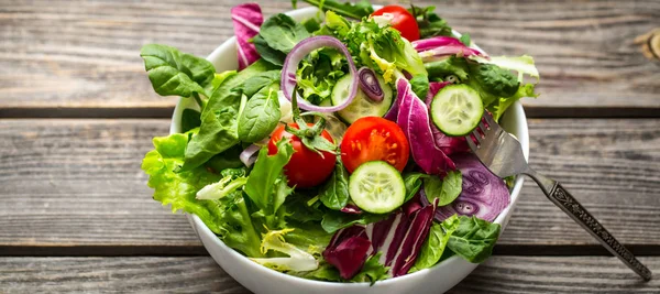 Frischer Salat auf einem hölzernen Hintergrund — Stockfoto