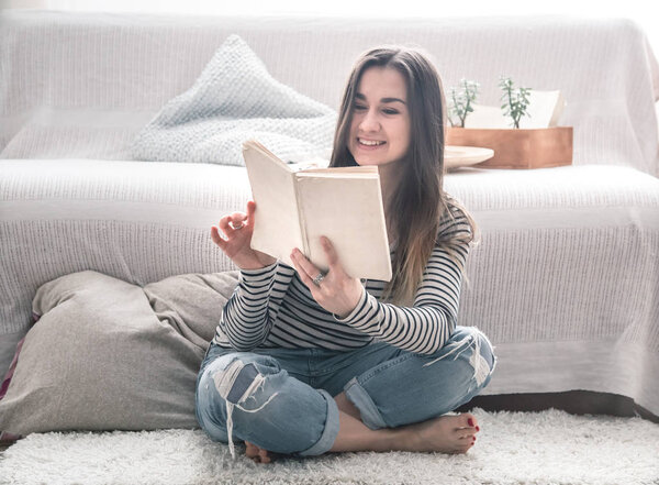 the girl is reading in the living room