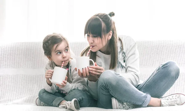 Мама и дочь пьют чай на диване. — стоковое фото