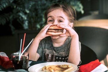 kafede hamburger ile küçük kız