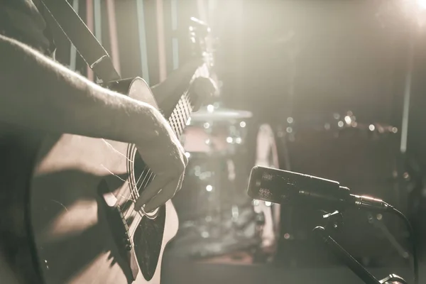 The Studio microphone records an acoustic guitar close-up. Beautiful blurred background of colored lanterns. — Stock Photo, Image