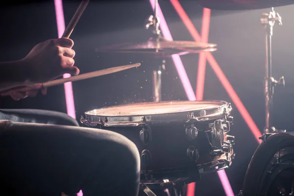 L'homme joue de la batterie. Sur le fond de lumières colorées . — Photo