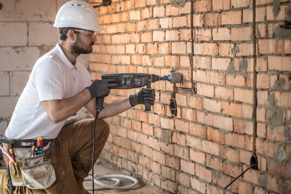 Handyman uses jackhammer, for installation, professional worker 