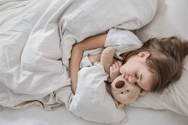 Linda niña en la cama con juguete suave . — Foto de Stock