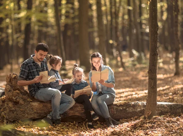 Famiglia insieme a leggere libri nella foresta  . — Foto Stock