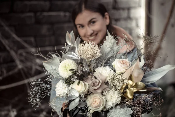 Mädchen mit einem Blumengesteck in einem Kürbis. — Stockfoto