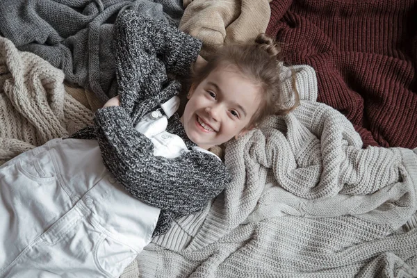 Cute little fun girl in a knitted sweater. — Stock Photo, Image