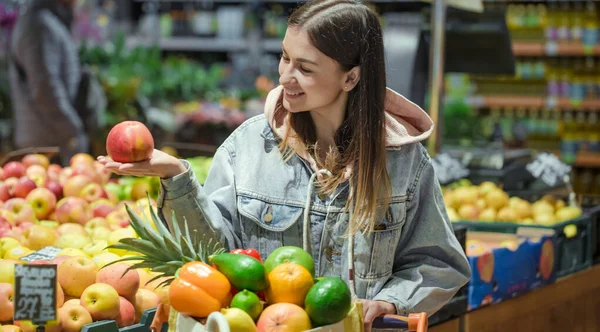 Genç bir kadın yiyecek bir süpermarkette satın alır.. — Stok fotoğraf