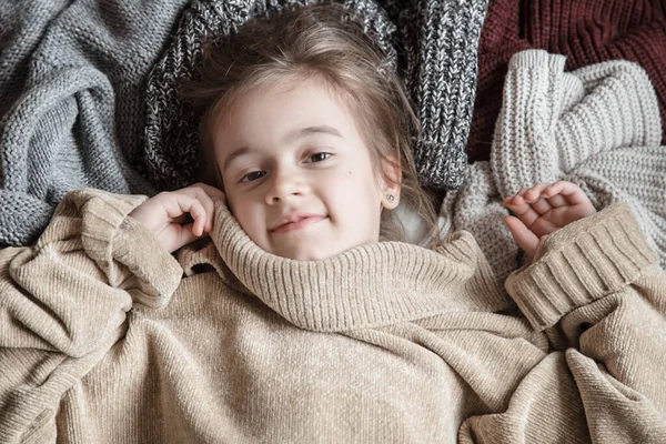 Cute little fun girl in a knitted sweater. — Stock Photo, Image