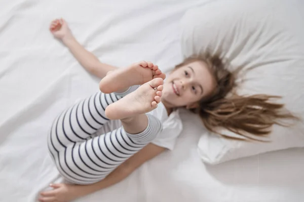 Nettes kleines Mädchen im Bett wachte am Morgen auf . — Stockfoto