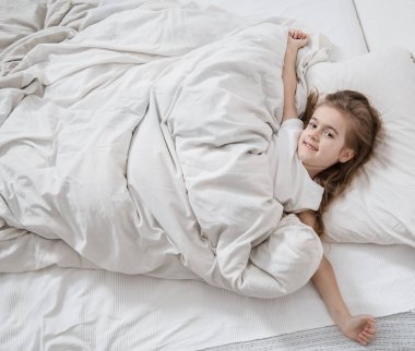 Yatakta küçük tatlı bir kız uyandı sabah .