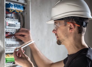 Elektrik santralinde fitili olan bir elektrik teknisyeni.