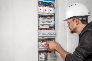 Elektrik santralinde fitili olan bir elektrik teknisyeni.