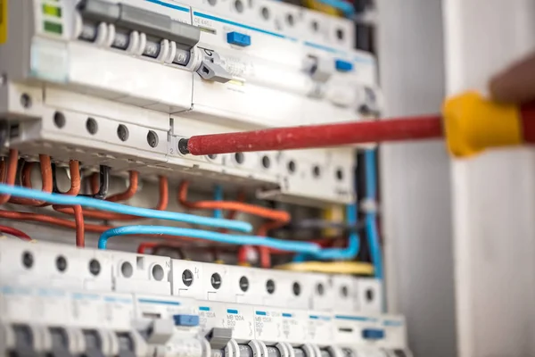 Mann, ein Elektrotechniker arbeitet in einem Schaltschrank mit Sicherung — Stockfoto