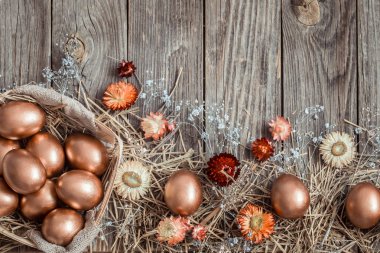 Ahşap zemin üzerinde Altın Paskalya yumurtaları olan bir arka plan.