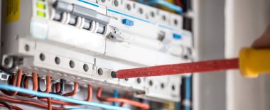 Elektrik santralinde fitili olan bir elektrik teknisyeni.