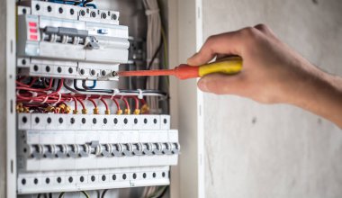 Elektrik santralinde fitili olan bir elektrik teknisyeni.