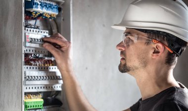 Elektrik santralinde fitili olan bir elektrik teknisyeni.