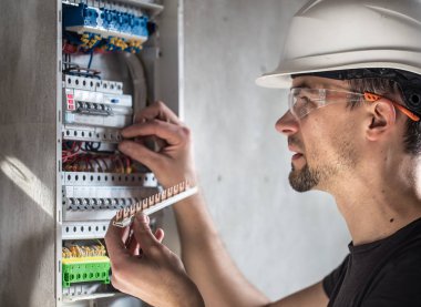 Elektrik santralinde fitili olan bir elektrik teknisyeni.