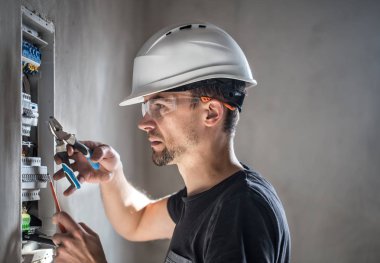 Elektrik santralinde fitili olan bir elektrik teknisyeni.