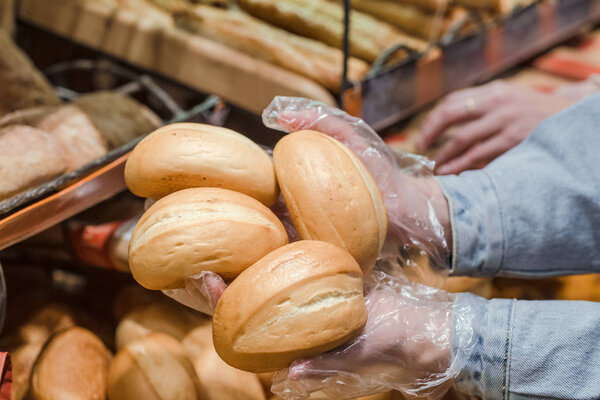 A young woman takes from the counter in the supermarket fresh br
