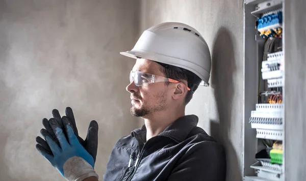 Man, een elektrotechnicus die werkt in een schakelbord met zekering — Stockfoto