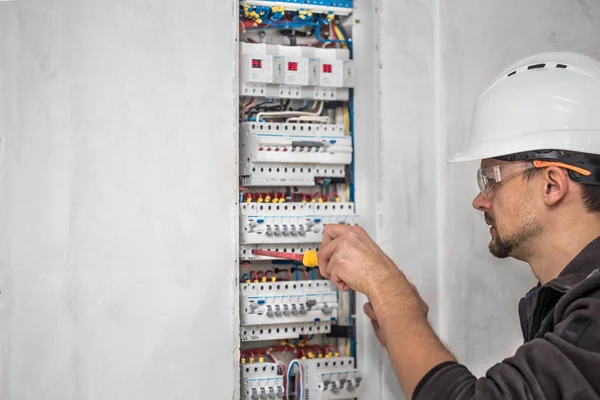 Man, een elektrotechnicus die werkt in een schakelbord met zekering — Stockfoto