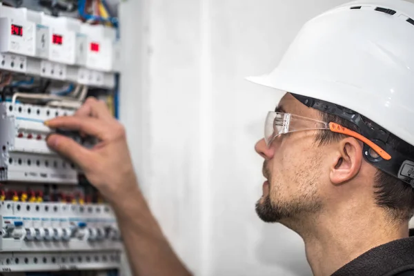 Man, en elektrisk tekniker som arbetar i en instrumenttavla med säkring — Stockfoto