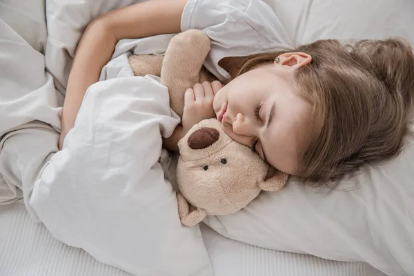 Cute little girl in bed with soft toy. — Stock Photo, Image