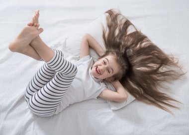 Yatakta küçük tatlı bir kız uyandı sabah .