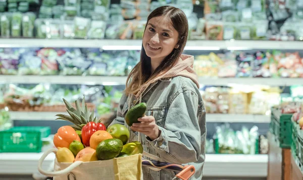 Genç bir kadın yiyecek bir süpermarkette satın alır.. — Stok fotoğraf
