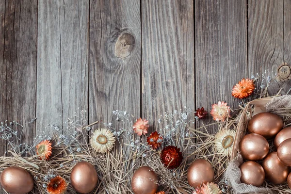 Achtergrond met gouden paaseieren op houten ondergrond. — Stockfoto