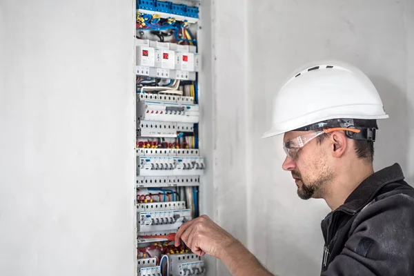 ヒューズ付きのスイッチボードで働いてる電気技術者だ電気設備の設置及び接続. — ストック写真