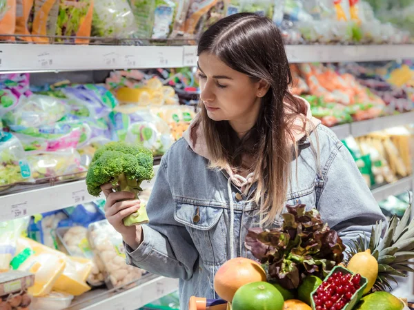 Genç bir kadın yiyecek bir süpermarkette satın alır.. — Stok fotoğraf