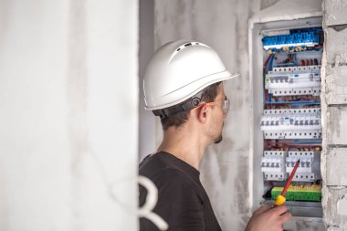 Elektrik santralinde fitili olan bir elektrik teknisyeni.