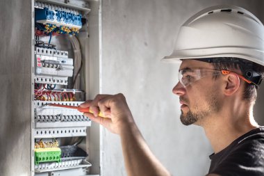 Elektrik santralinde fitili olan bir elektrik teknisyeni.