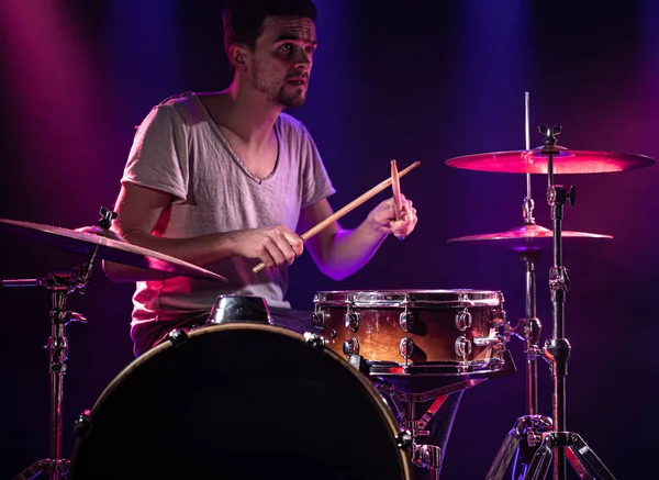 O baterista toca bateria. Belo fundo azul e vermelho , — Fotografia de Stock