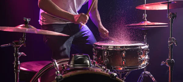 El baterista toca la batería. Hermoso fondo azul y rojo , — Foto de Stock