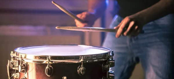 Man playing the snare drum on a beautiful colored background — Stockfoto