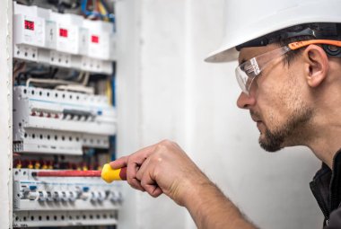 Elektrik santralinde fitili olan bir elektrik teknisyeni.