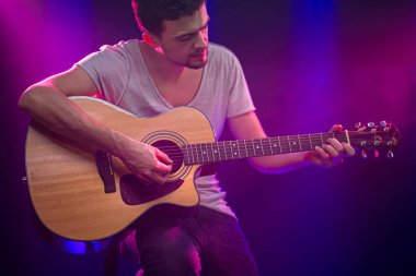 Müzisyen akustik gitar çalar. Birlikte güzel arkaplan