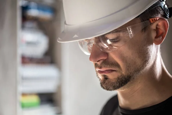 man, an electrical technician working in a switchboard with fuse