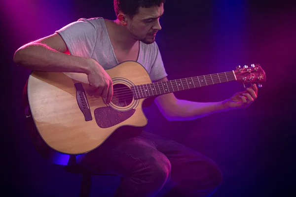 O músico toca guitarra acústica. Fundo bonito com — Fotografia de Stock