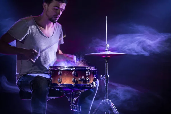 Барабанщик грає на барабанах на синьому фоні. Прекрасний спеціальний ефір — стокове фото