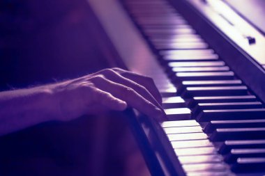 Erkek elleri piyano tuşlarının üzerinde Güzel renkli bir torbaya yakın çekim